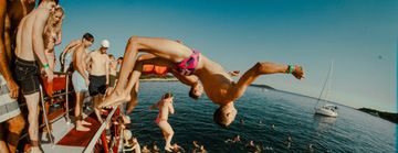 a guy diving into water from a boat